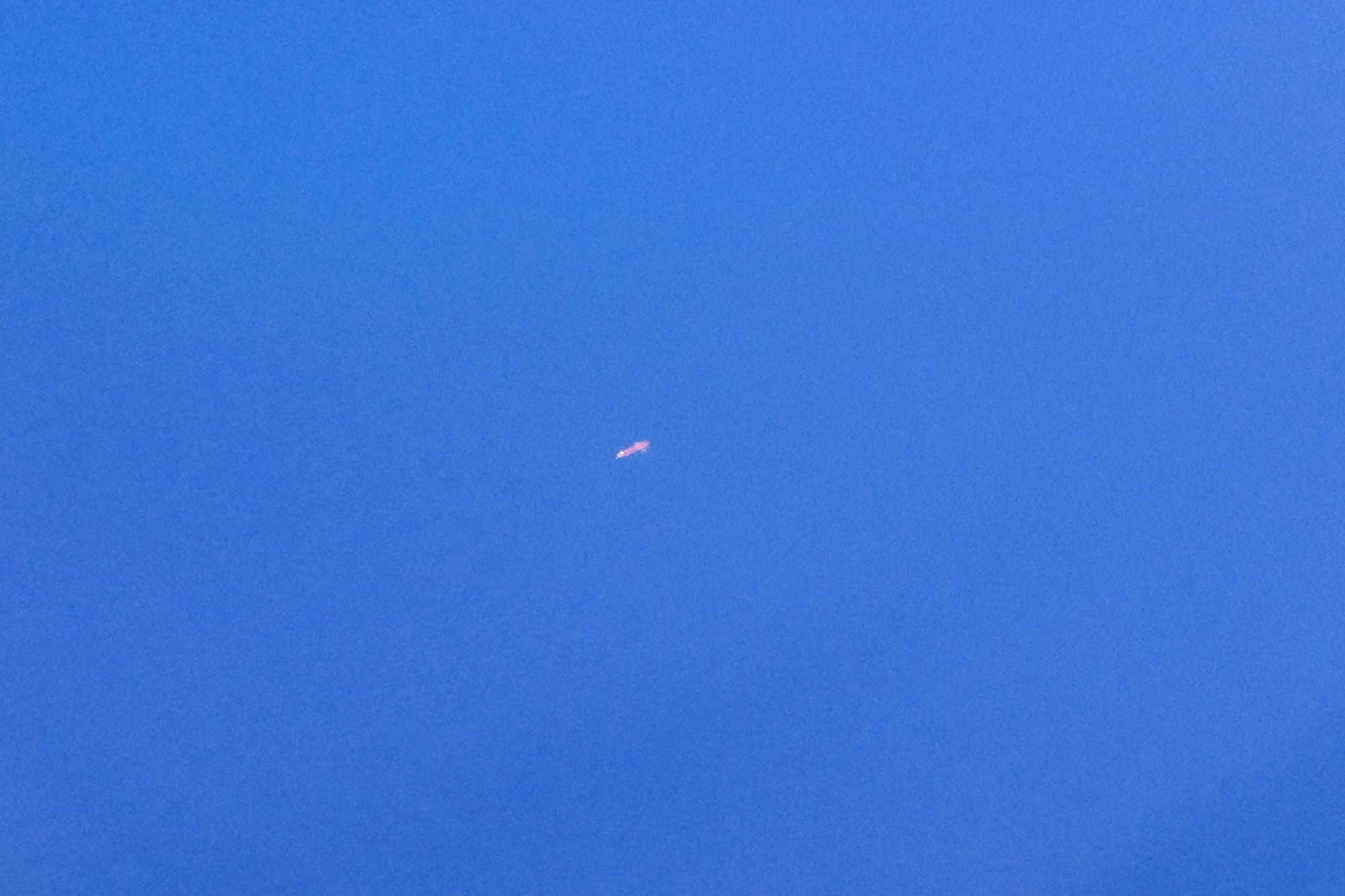 A tanker ship in the middle of the Atlantic Ocean from a plane window