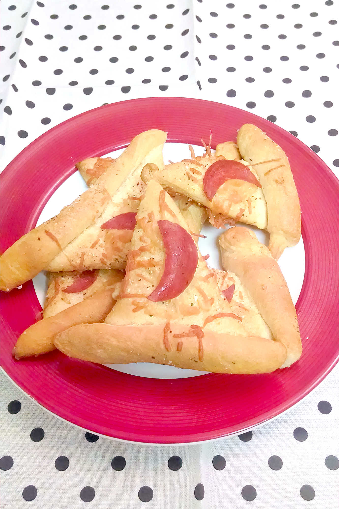 These Witch Hats are incredibly easy to make and disappear faster than you can say "Hocus Pocus." We used savory parmesan and moon-shaped pepperoni for an extra spooky touch. The perfect treat for your next movie night or costume party! #witchhats #halloweenfood #halloweensnacks #easyhalloweenideas #spookyseason #halloweenpartyfood #halloweenrecipes #kidfriendlyfood #hocuspocus #allhallowseve