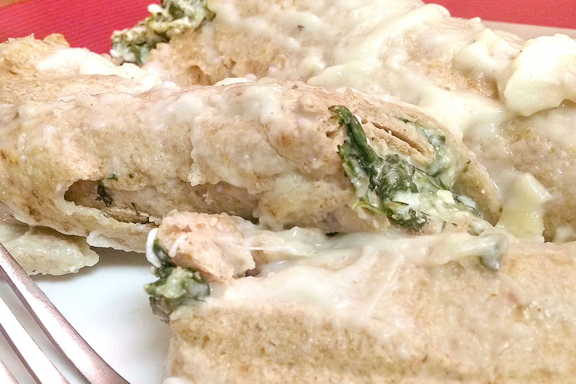 Meet your new favorite twist on comfort food. These Spinach Florentine Enchiladas are rolled just like manicotti and filled with a creamy spinach and cheese blend that will keep you coming back for more. #SpinachFlorentineEnchiladas #MeatlessMonday #VegetarianEats #HealthyComfortFood #EnchiladaRecipeOfTheDay