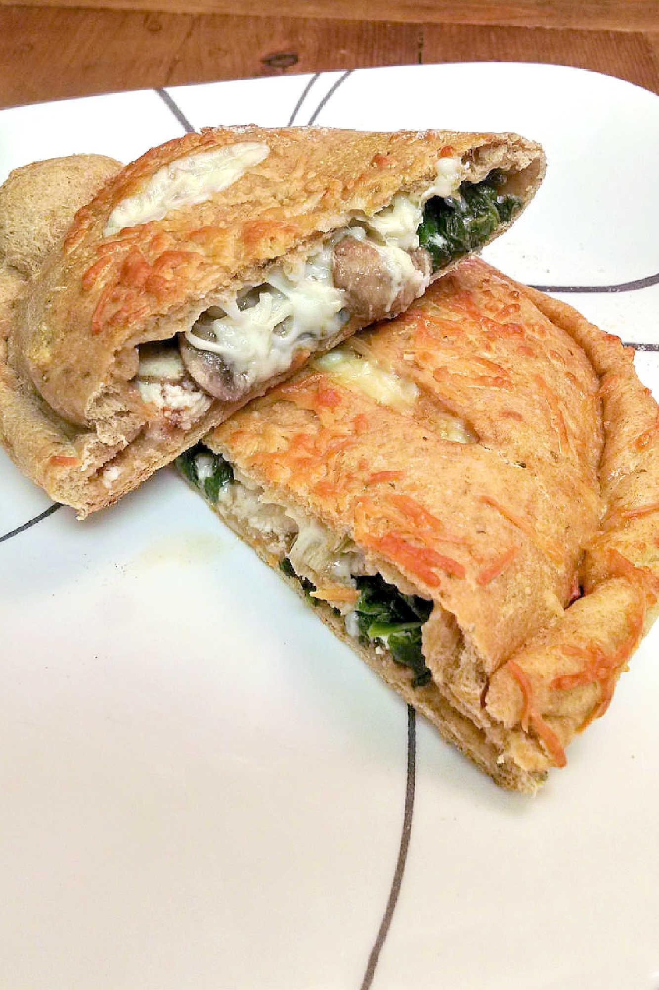 Spinach Mushroom Ricotta Calzones are a delicious and healthy twist on the classic Italian dish. Perfect for a cozy night in or a family dinner (and sneaking in veggies). #weeknightdinner #calzones #easyrecipe #pizzanight #calzones #homemade #ItalianComfortFood #HomemadeBread #VegetarianEats #RicottaCheeseLove #MeatlessMondays
