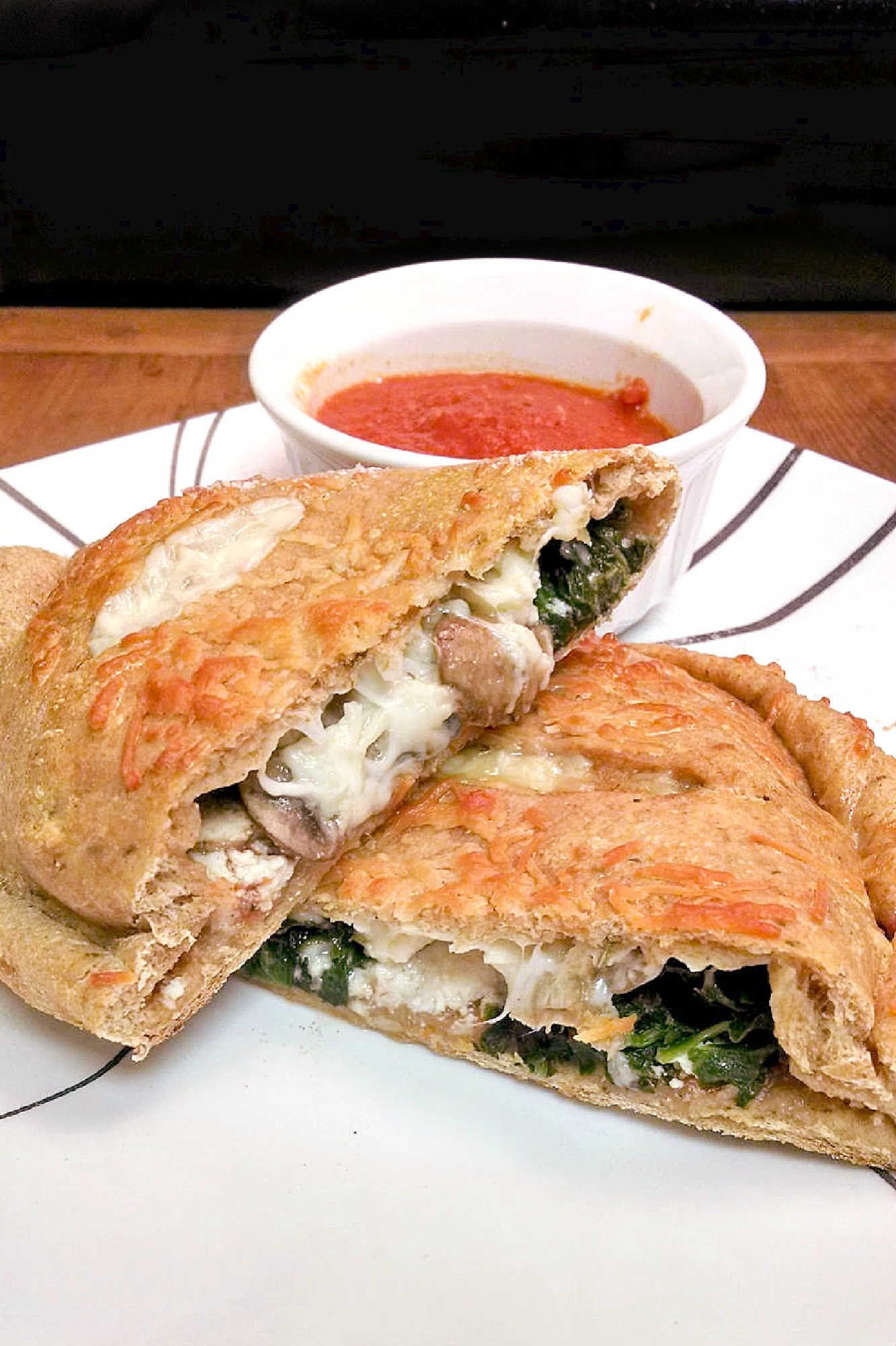 Spinach Mushroom Ricotta Calzones are a delicious and healthy twist on the classic Italian dish. Perfect for a cozy night in or a family dinner (and sneaking in veggies). #weeknightdinner #calzones #easyrecipe #pizzanight #calzones #homemade #ItalianComfortFood #HomemadeBread #VegetarianEats #RicottaCheeseLove #MeatlessMondays