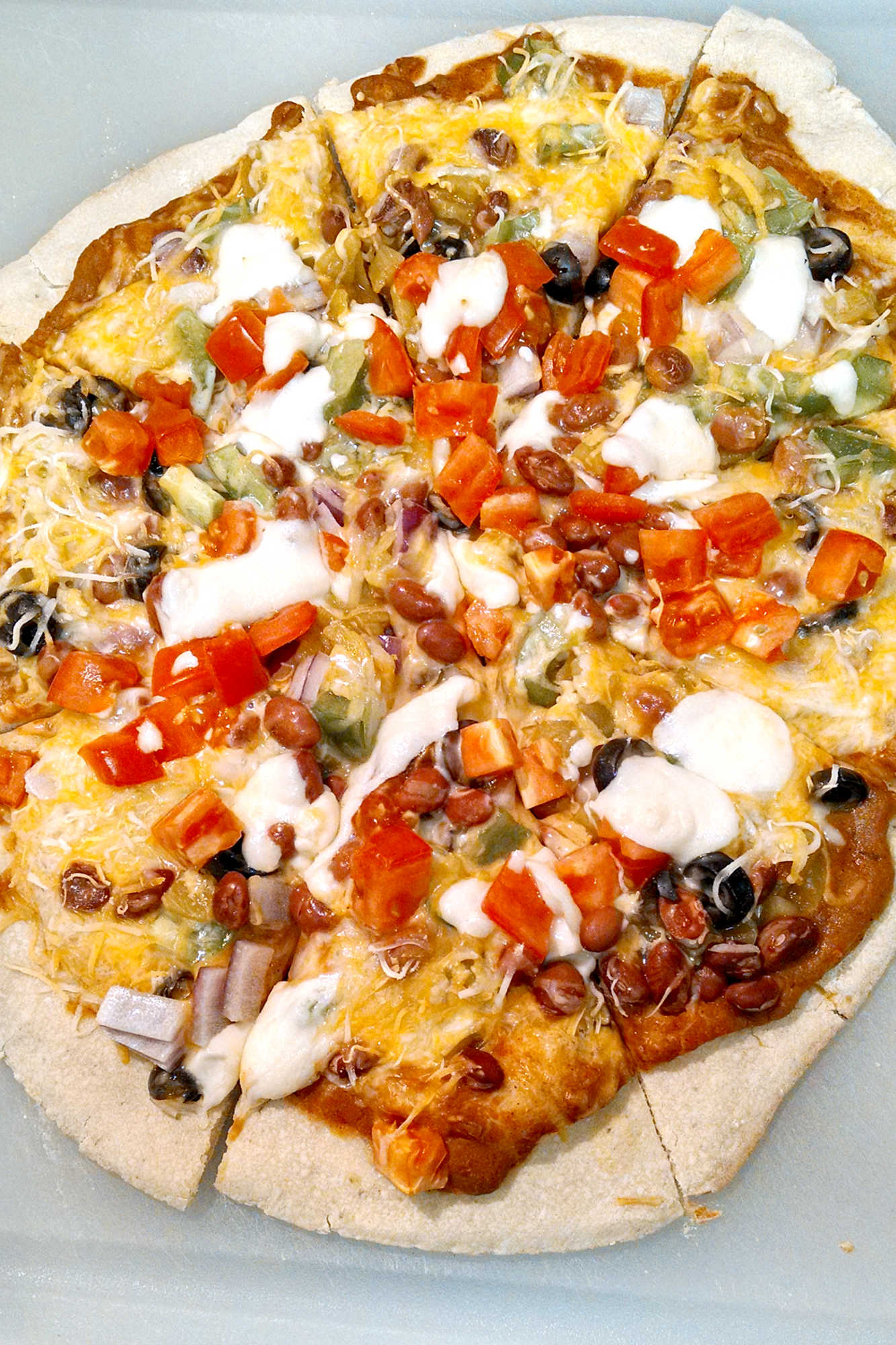 Is it pizza or is it a taco? Why not both! Try this unique and tasty Mexican Pizza for the perfect combination of both worlds! #MexicanPizzaMadness #TacoTuesdayTreat #CincoDeMayoEats #SpicySaborSensation #TortillaToppedDelight #meatfree 