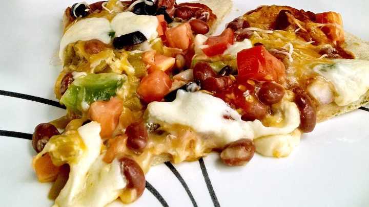 Is it pizza or is it a taco? Why not both! Try this unique and tasty Mexican Pizza for the perfect combination of both worlds! #MexicanPizzaMadness #TacoTuesdayTreat #CincoDeMayoEats #SpicySaborSensation #TortillaToppedDelight #meatfree