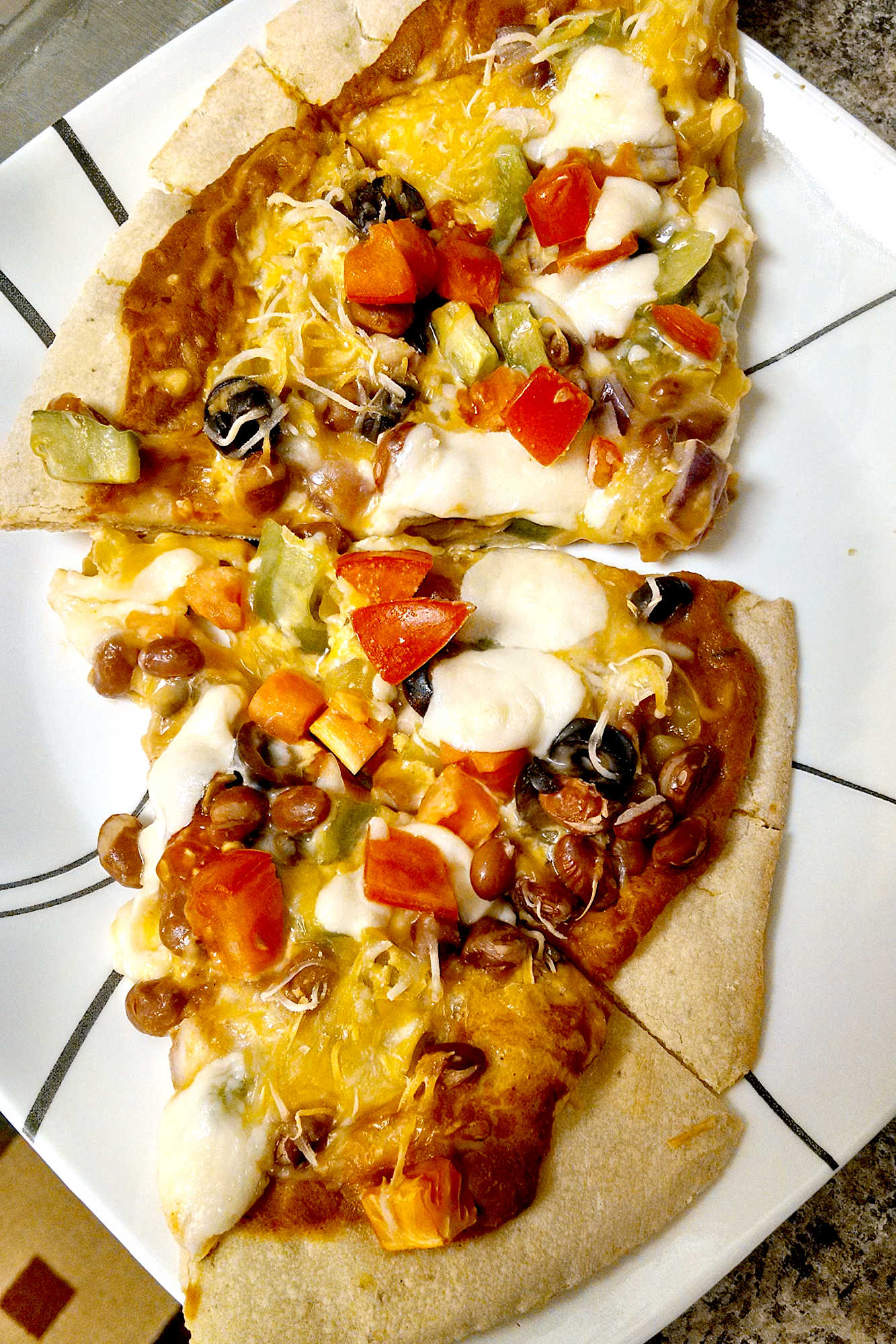 Is it pizza or is it a taco? Why not both! Try this unique and tasty Mexican Pizza for the perfect combination of both worlds! #MexicanPizzaMadness #TacoTuesdayTreat #CincoDeMayoEats #SpicySaborSensation #TortillaToppedDelight #meatfree 