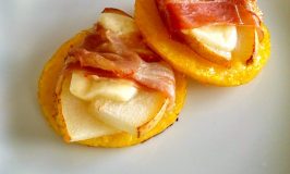 Pear, Proscuitto, Polenta Bites | A Kitchen Hoor's Adventures | Polenta rounds are baked until crisp then topped with pears wrapped in prosciutto and baked until the prosciutto is crisp