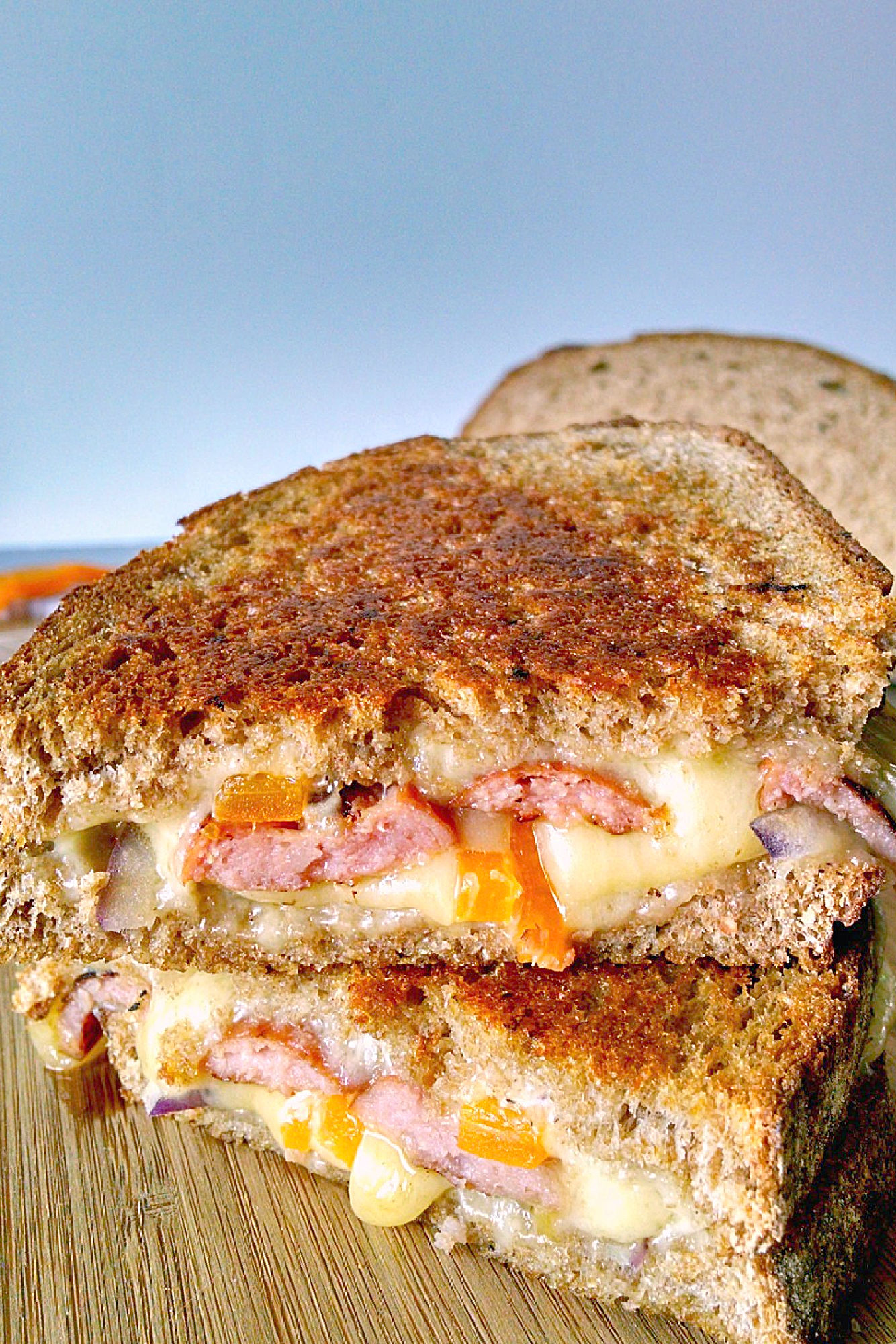 Kielbasa, onions, and peppers are melted Monterey Jack in this simple Saturday Kielbasa Grilled Cheese. Monterey Jack cheese has a delicious sharpness that pairs well with the smoky sausage, sweet peppers, and red onions. #GrilledCheeseMonth #kielbasa #sandwich #grilledcheeselover