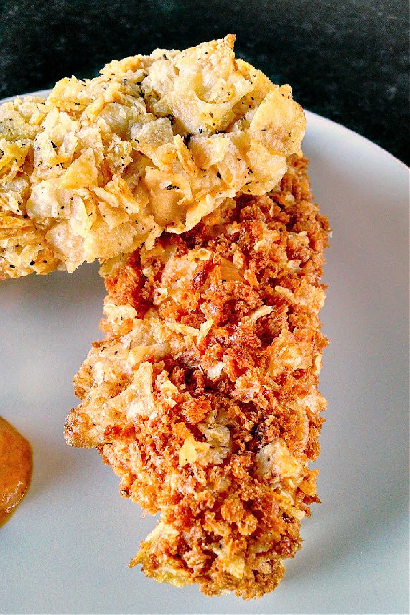 Spice up your chicken game with these oven-fried potato chip chicken tenders! With a crispy potato chip coating and juicy chicken inside, this dish is sure to be a crowd-pleaser. Try them out for your next game day or movie night.  #ovenfriedchicken #potatochipchicken #easyrecipes #crispychicken #homecookingmadetasty