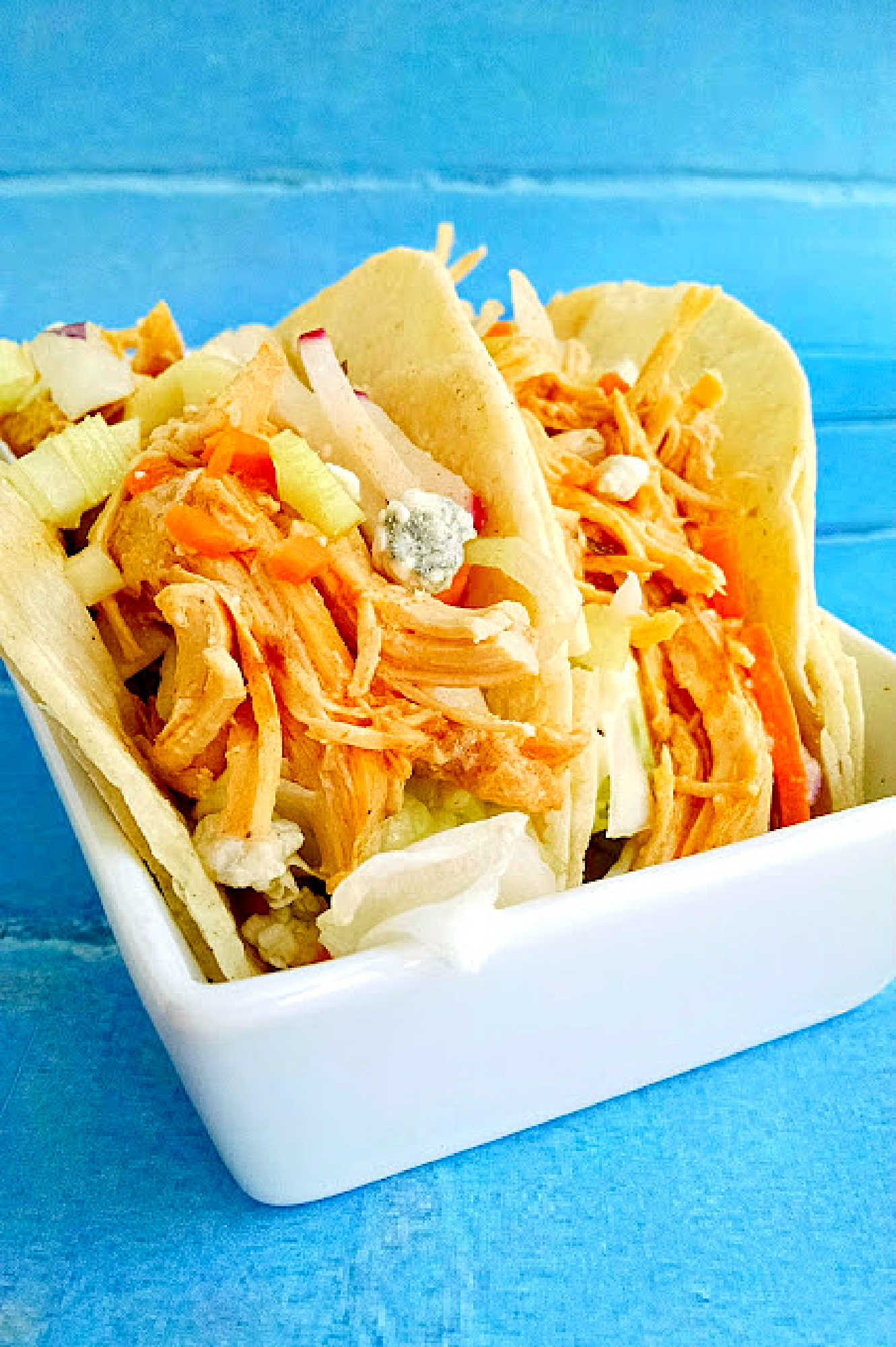 These Buffalo Chicken Tacos with Blue Cheese Radish Slaw will knock your taste buds off! And your family will want these ALL time. Don’t say I didn’t warn you! #OurFamilyTable #BuffaloChicken #chickentacos #bluecheeseslaw #radishslaw #slowcooker #BuffaloChickenTacos #TacoTuesday #GameDay