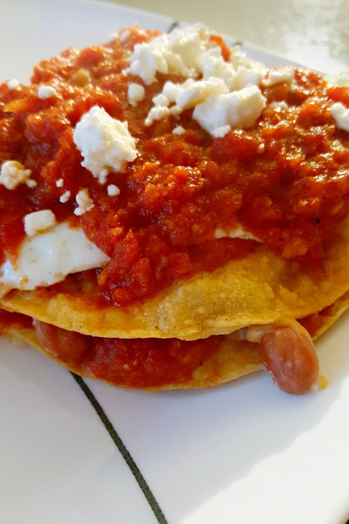 Crispy tostada stacks hold hearty beans and a spicy tomato sauce before topped with a fried egg. These Huevos Rancheros Tostadas stacks are deliciously spicy for an international brunch or just a #meatfree dinner.