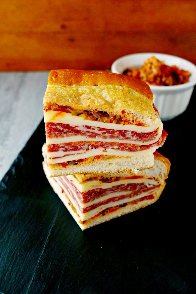 This is a muffaletta you could easy make for a crowd or a picnic. Overnight Muffaletta Sandwich is quick to make but tastes oh so delicious! Laissez les bons temps rouler!! #OvernightMuffaletta #SandwichSavant #MuffalettaMania #FoodieFaves #picnicsandwich #pressedsandwich