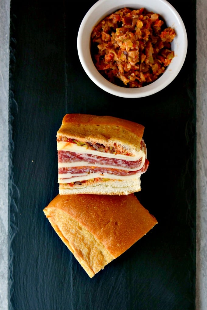 This is a muffaletta you could easy make for a crowd or a picnic. Overnight Muffaletta Sandwich is quick to make but tastes oh so delicious! Laissez les bons temps rouler!! #OvernightMuffaletta #SandwichSavant #MuffalettaMania #FoodieFaves #picnicsandwich #pressedsandwich