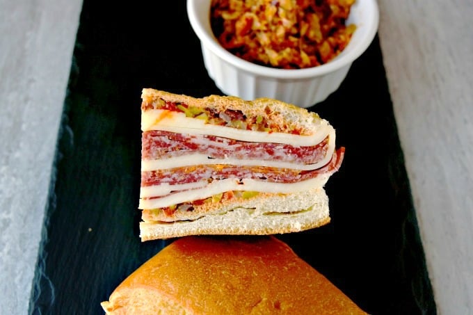 This is a muffaletta you could easy make for a crowd or a picnic. Overnight Muffaletta Sandwich is quick to make but tastes oh so delicious! Laissez les bons temps rouler!! #OvernightMuffaletta #SandwichSavant #MuffalettaMania #FoodieFaves #picnicsandwich #pressedsandwich