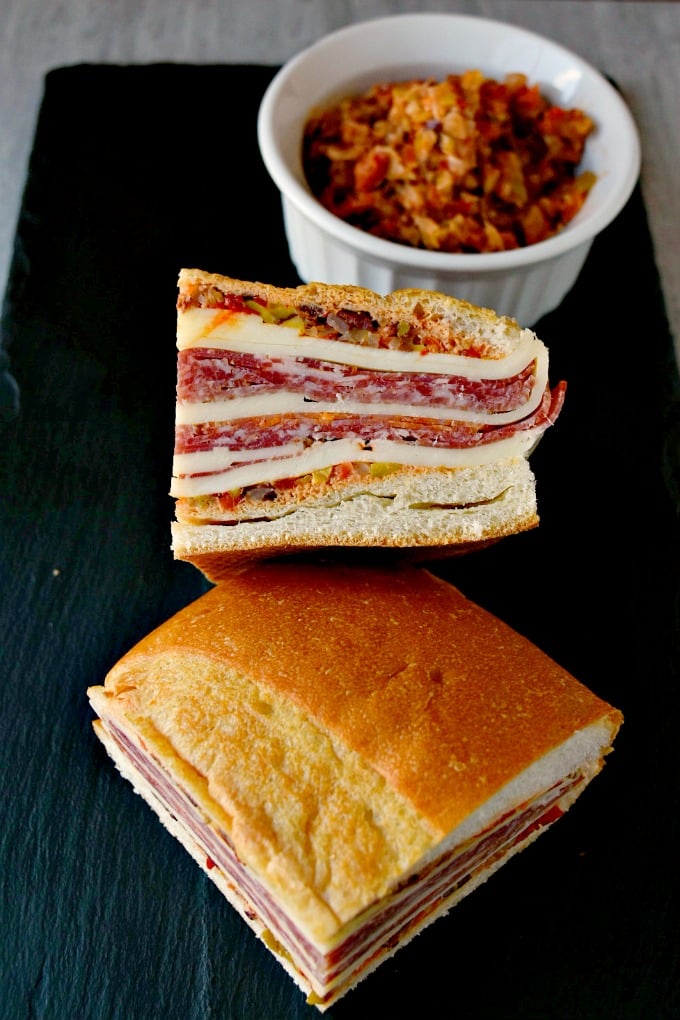 This is a muffaletta you could easy make for a crowd or a picnic. Overnight Muffaletta Sandwich is quick to make but tastes oh so delicious! Laissez les bons temps rouler!! #OvernightMuffaletta #SandwichSavant #MuffalettaMania #FoodieFaves #picnicsandwich #pressedsandwich