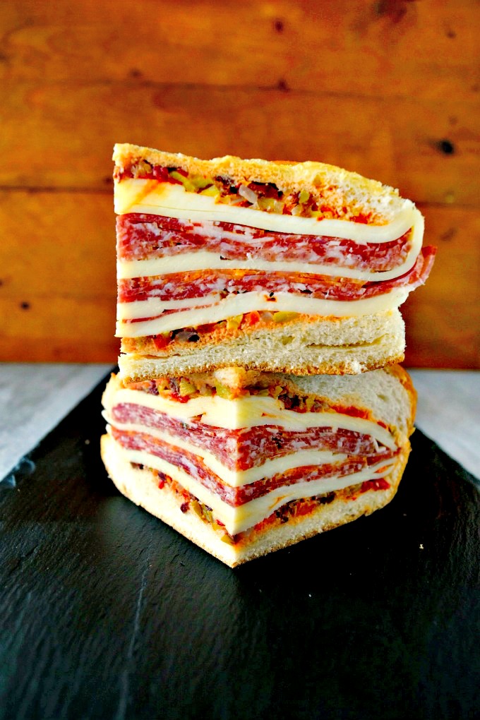 This is a muffaletta you could easy make for a crowd or a picnic. Overnight Muffaletta Sandwich is quick to make but tastes oh so delicious! Laissez les bons temps rouler!! #OvernightMuffaletta #SandwichSavant #MuffalettaMania #FoodieFaves #picnicsandwich #pressedsandwich