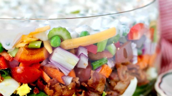 The Ultimate Layered Salad with iceberg, baby spinach, bacon, and peas (and lots of other veggies) is a reminder of those potlucks and recipe books put together by church groups, babysitting co-ops, charity groups, and women's clubs.