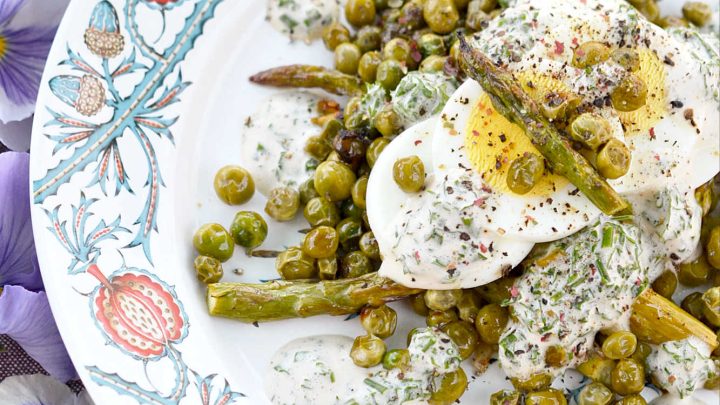 This warm roasted vegetable salad uses fresh asparagus, frozen peas, and garlic to create an absolutely unforgettable spring salad. Topped with sliced hard-boiled eggs and a creamy parsley and chive dressing, this salad is anything but boring.