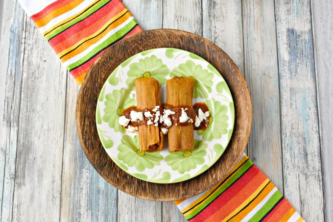 Savory pumpkin masa dough is filled with spicy pork chorizo.  Pumpkin Chorizo Tamales with Pumpkin Mole is a flavor-plosion in your mouth!  If that's not enough, they're topped with rich pumpkin mole and creamy queso blanco.  #PumpkinWeek