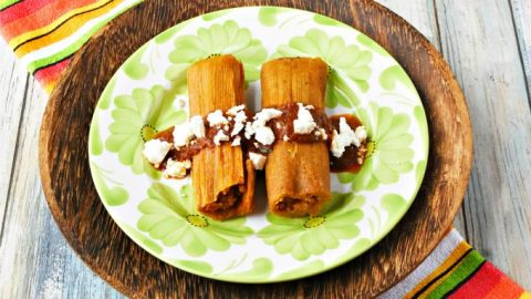 Savory pumpkin masa dough is filled with spicy pork chorizo.  Pumpkin Chorizo Tamales with Pumpkin Mole is a flavor-plosion in your mouth!  If that's not enough, they're topped with rich pumpkin mole and creamy queso blanco.  #PumpkinWeek