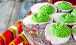 Simple deviled eggs are turned into a fun and delicious Halloween party appetizer.  Dragons Eggs are avocado deviled eggs with a kick of garlic making them creamy with a spicy garlic kick.  #HalloweenTreatsWeek