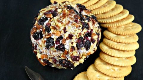 Cranberry Cheese Ball has a simple name, but not simple flavors. Dried cranberries, rosemary, Menorca Spanish cheese, and cream cheese all come together for a delicious cheese ball rolled in roasted pecans and dried cranberries. It’s the perfect appetizer for the holidays.