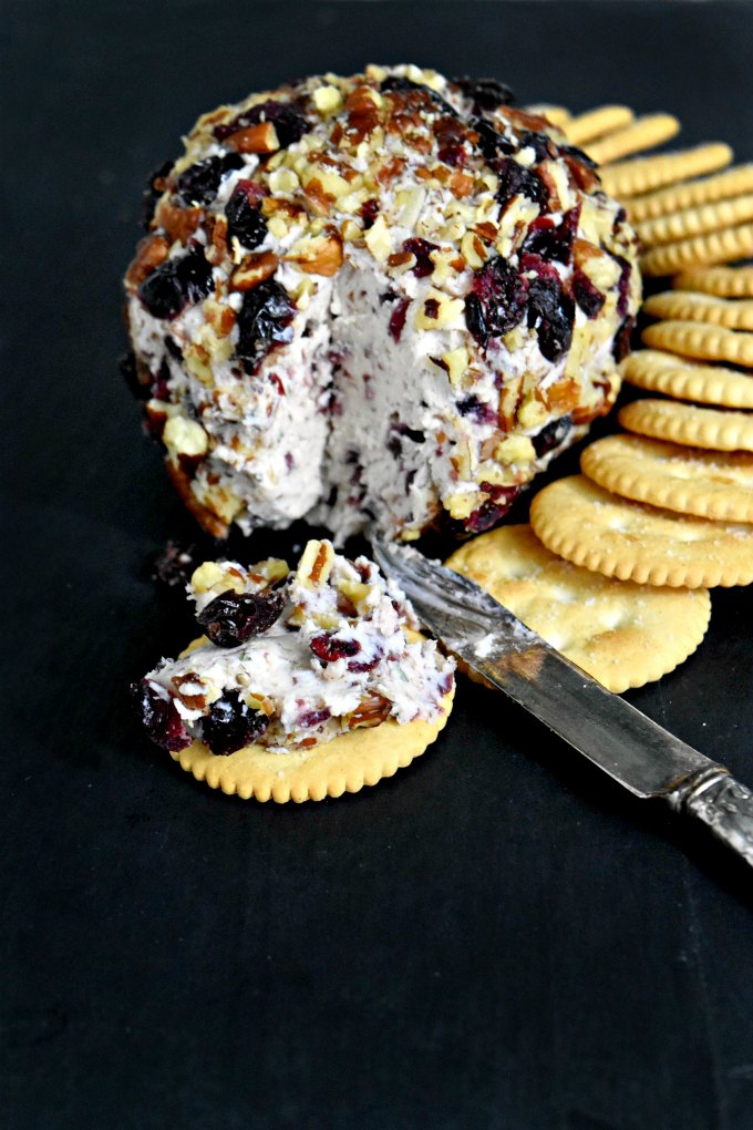 Cranberry Cheese Ball has a simple name, but not simple flavors. Dried cranberries, rosemary, Menorca Spanish cheese, and cream cheese all come together for a delicious cheese ball rolled in roasted pecans and dried cranberries. It’s the perfect appetizer for the holidays.