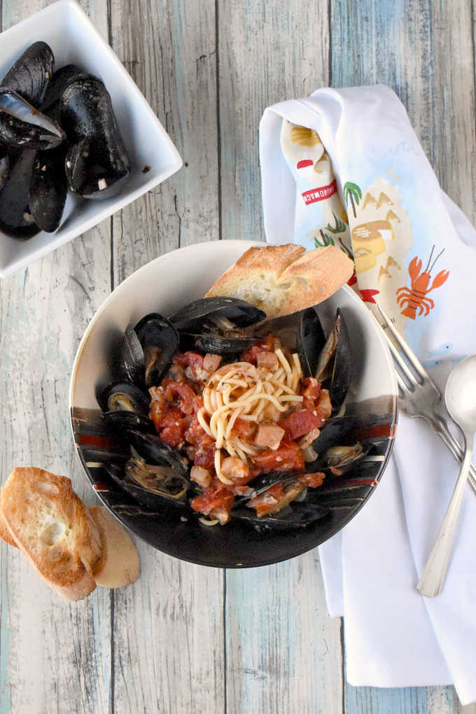 Tender mussels swim in a white wine tomato broth with garlic, shallots, proscuitto, and herbs.  Perfect for date night or a dinner party, Spicy Mussels Provençal are similar to a bouillabaisse style dish with less broth and a little more spice.  Oh, and pasta. 