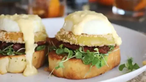 Classic eggs benedict is great and all, but have you tried it with fried green tomato, served on Texas toast, and topped with cheddar hollandaise?
