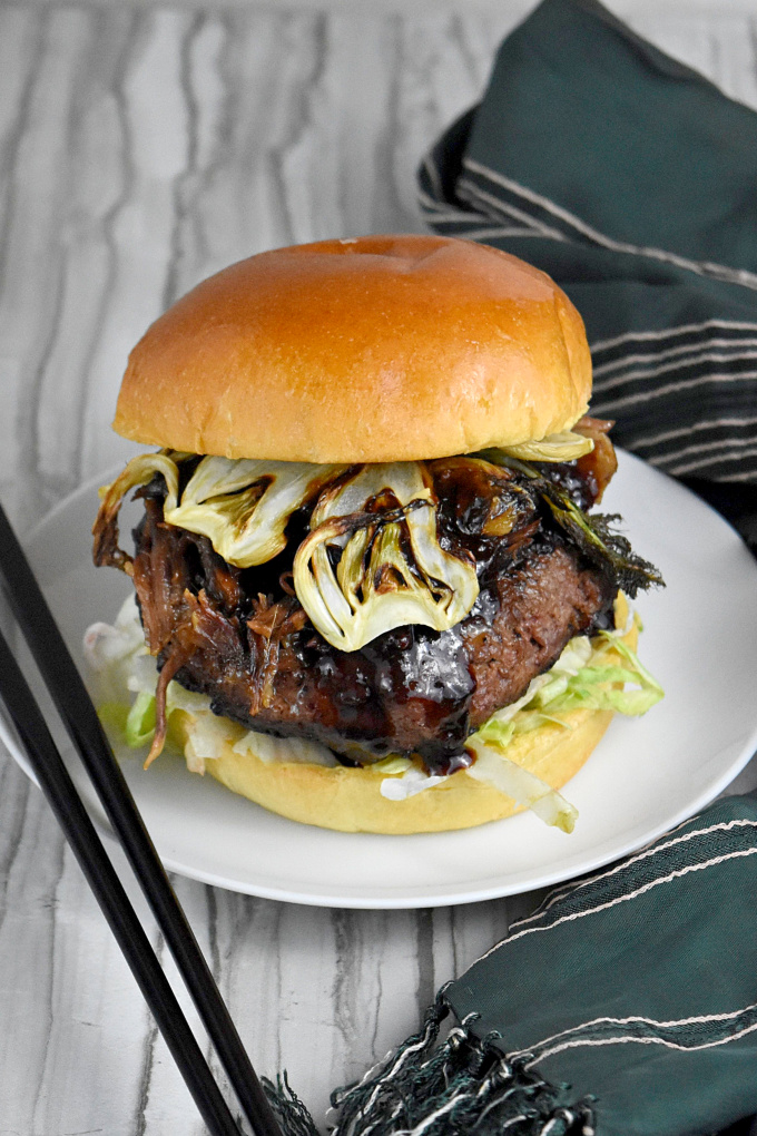 Asian Inspired Short Rib Burger has soy, ginger, sesame oil, and hoisin sauce. It's topped with braised short ribs marinated with lemongrass, garlic, ginger, and soy sauce and crispy fennel chips. It's packs mouthful after delicious mouthful of flavor. #BurgerMonth