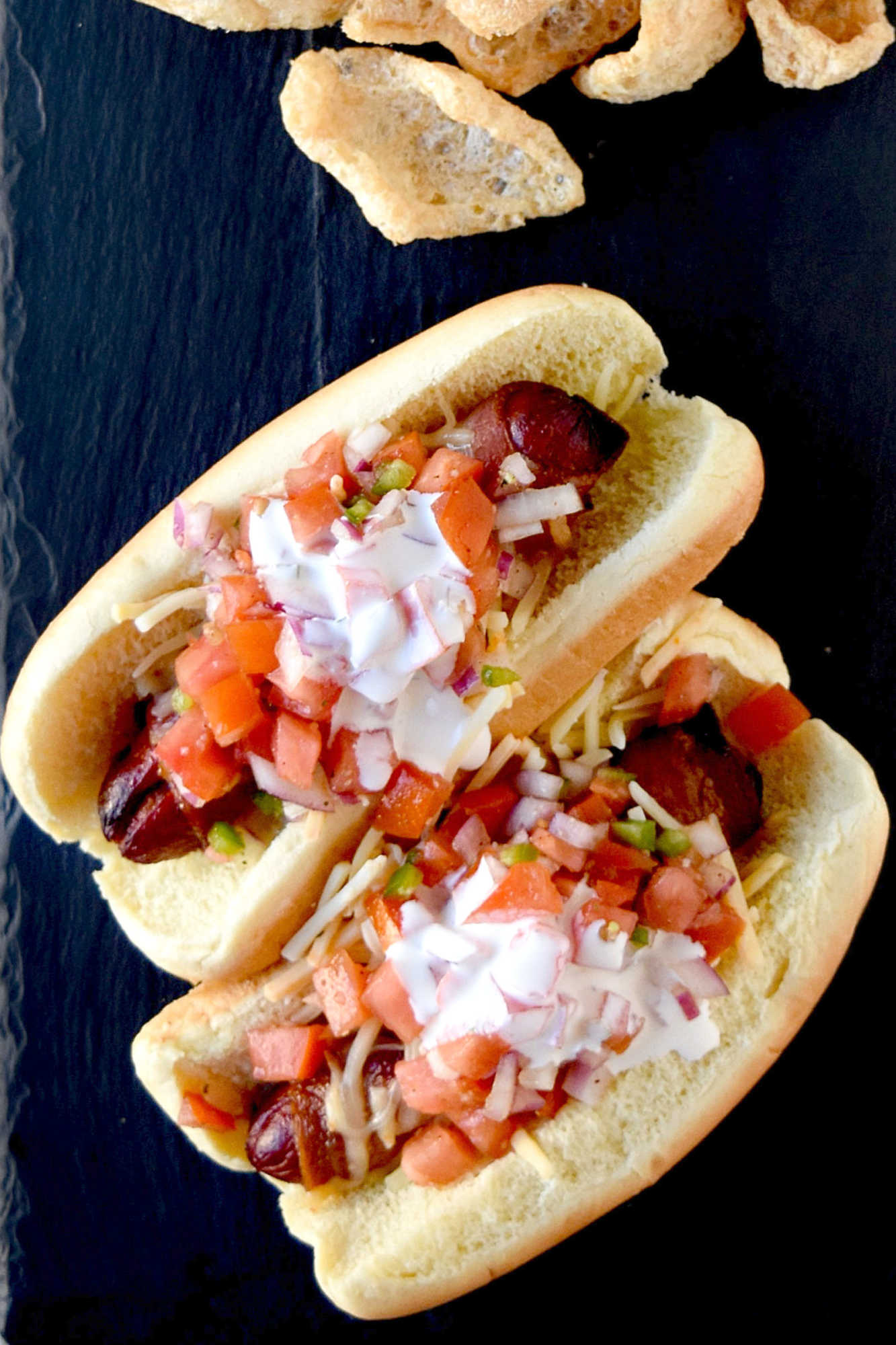 Air Fryer Bacon Wrapped Hot Dogs are simple to make and elevated with pico de gallo and crema toppings. The smoky and salty bacon complements the crisp and cool pico and rich crema. #OurFamilyTable