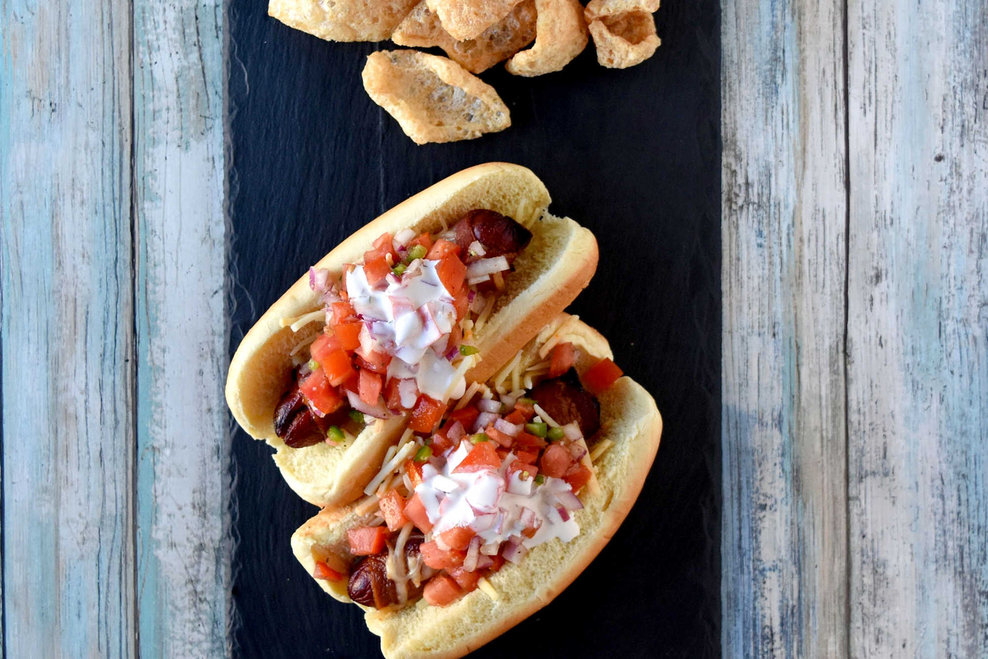 Air Fryer Bacon Wrapped Hot Dogs are simple to make and elevated with pico de gallo and crema toppings. The smoky and salty bacon complements the crisp and cool pico and rich crema. #OurFamilyTable