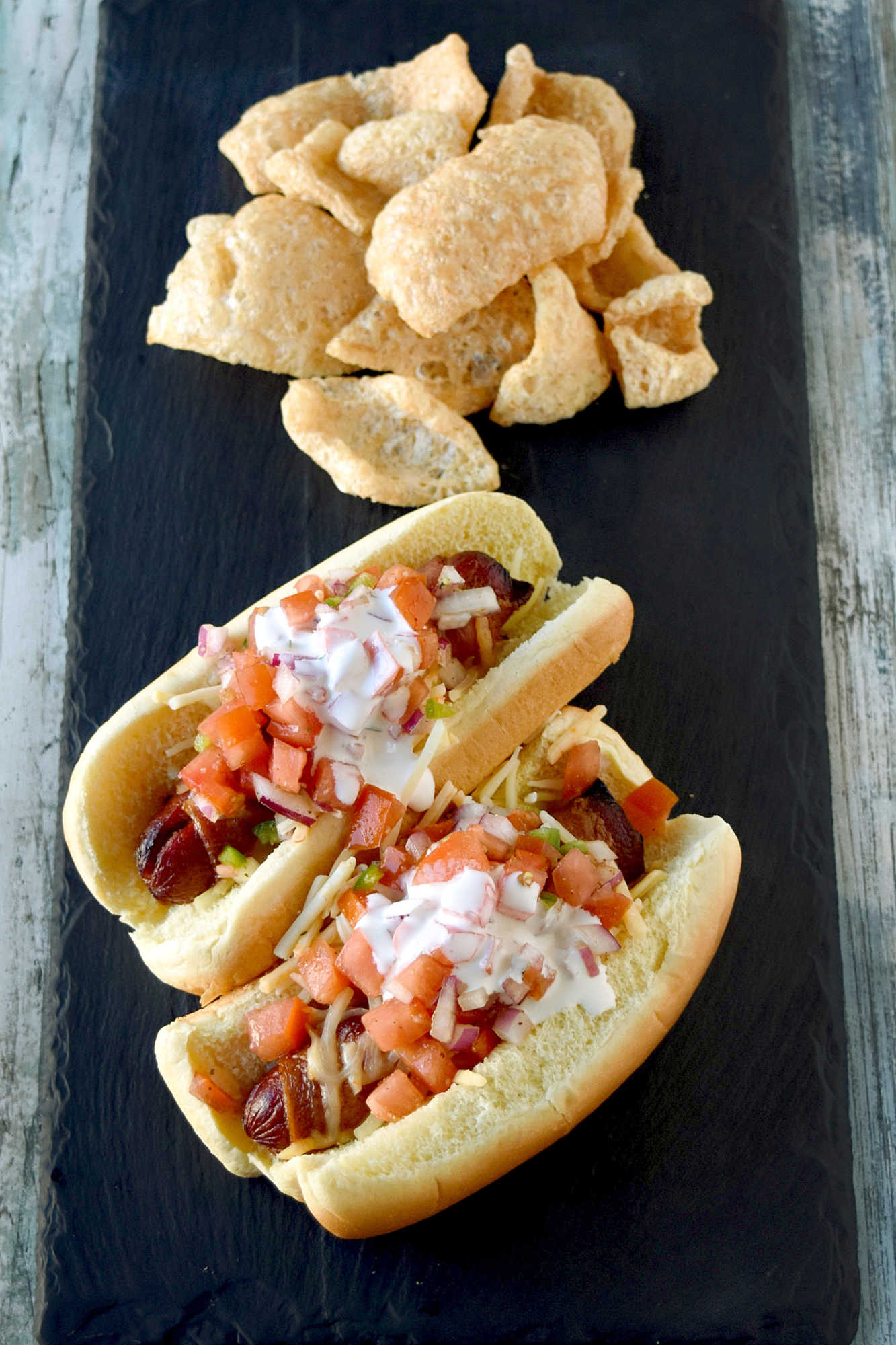 Air Fryer Bacon Wrapped Hot Dogs are simple to make and elevated with pico de gallo and crema toppings. The smoky and salty bacon complements the crisp and cool pico and rich crema. #OurFamilyTable
