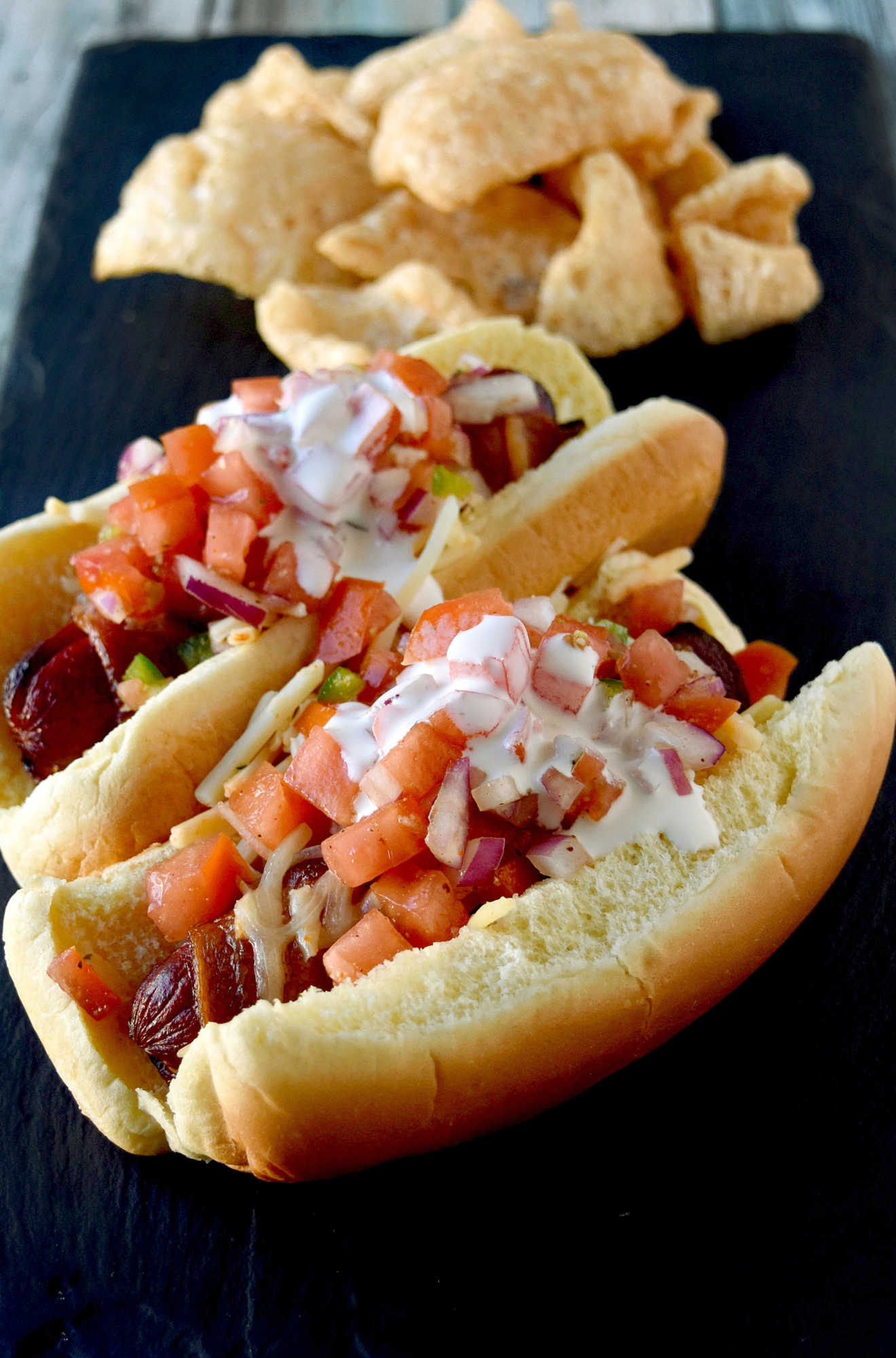 Air Fryer Bacon Wrapped Hot Dogs are simple to make and elevated with pico de gallo and crema toppings. The smoky and salty bacon complements the crisp and cool pico and rich crema. #OurFamilyTable
