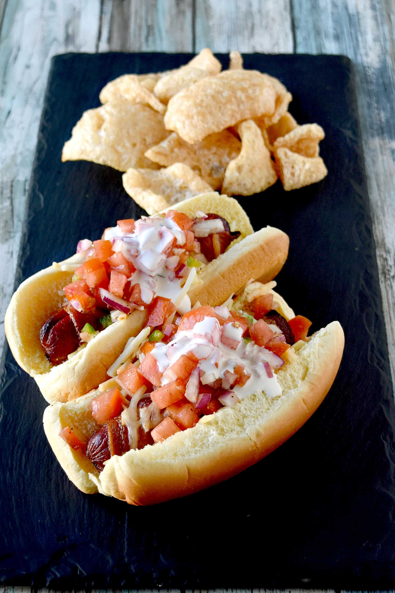 Air Fryer Bacon Wrapped Hot Dogs are simple to make and elevated with pico de gallo and crema toppings. The smoky and salty bacon complements the crisp and cool pico and rich crema. #OurFamilyTable