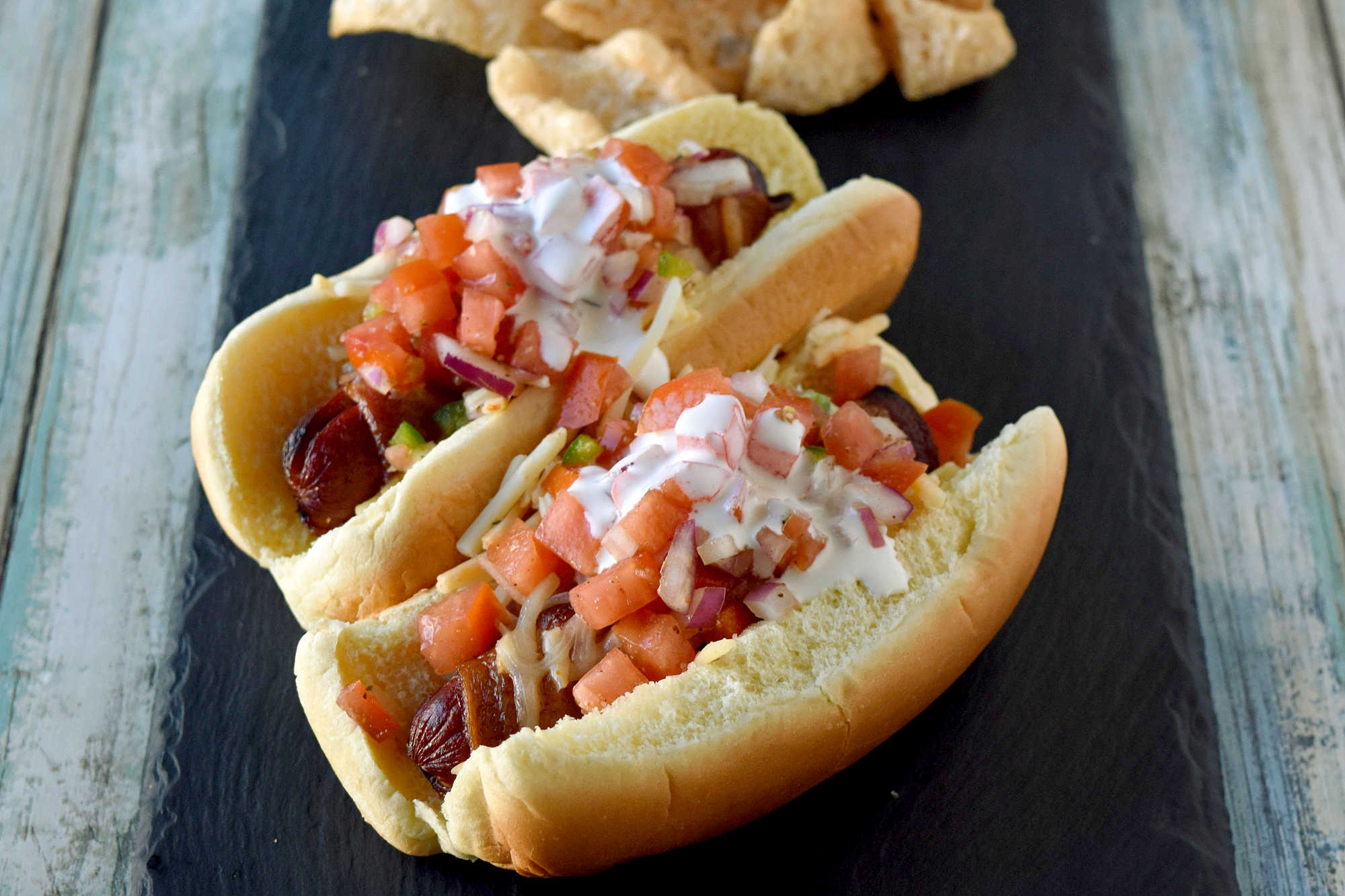 Air Fryer Bacon Wrapped Hot Dogs are simple to make and elevated with pico de gallo and crema toppings. The smoky and salty bacon complements the crisp and cool pico and rich crema. #OurFamilyTable