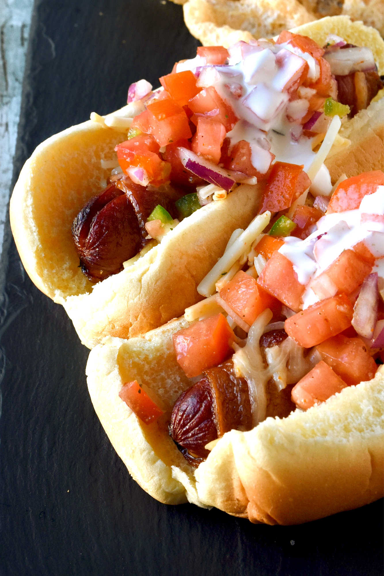 Air Fryer Bacon Wrapped Hot Dogs are simple to make and elevated with pico de gallo and crema toppings. The smoky and salty bacon complements the crisp and cool pico and rich crema. #OurFamilyTable