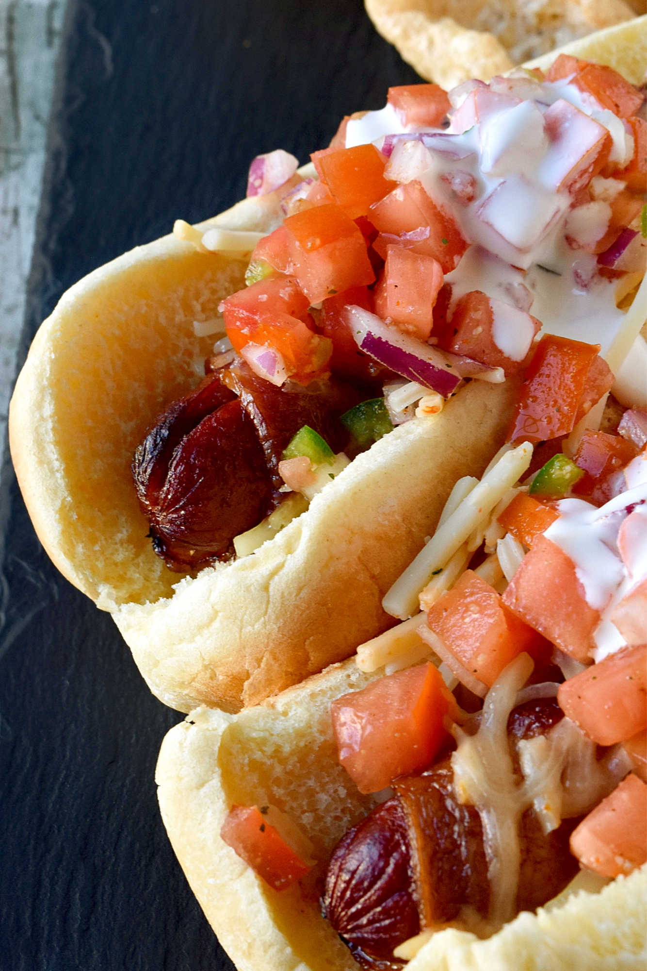 Air Fryer Bacon Wrapped Hot Dogs are simple to make and elevated with pico de gallo and crema toppings. The smoky and salty bacon complements the crisp and cool pico and rich crema. #OurFamilyTable