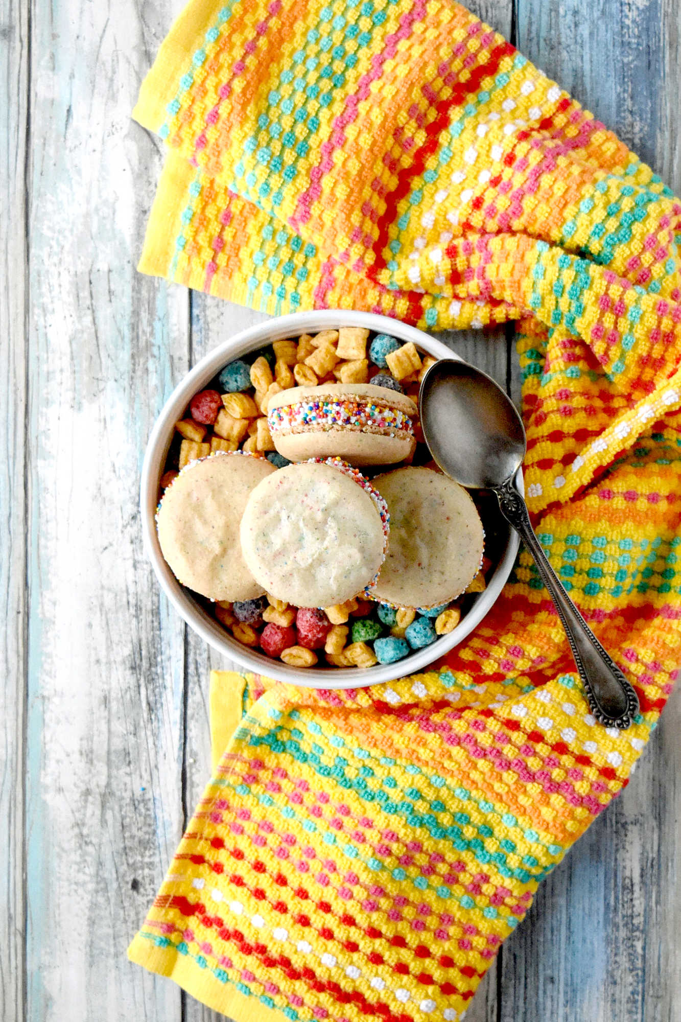 Cereal Milk Macaron taste like your favorite fruit cereal.  There's cereal in the shells and cereal milk in the buttercream.   #BacktoSchoolTreats