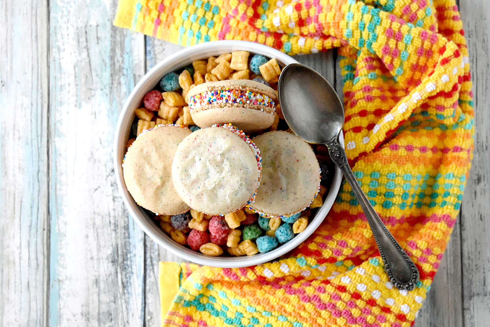 Cereal Milk Macaron taste like your favorite fruit cereal.  There's cereal in the shells and cereal milk in the buttercream.   #BacktoSchoolTreats