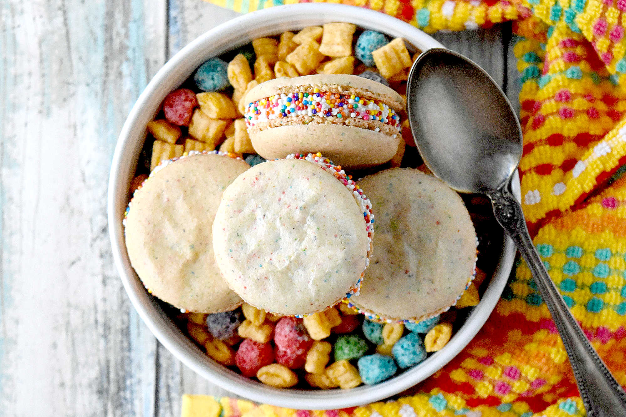 Cereal Milk Macaron taste like your favorite fruit cereal.  There's cereal in the shells and cereal milk in the buttercream.   #BacktoSchoolTreats
