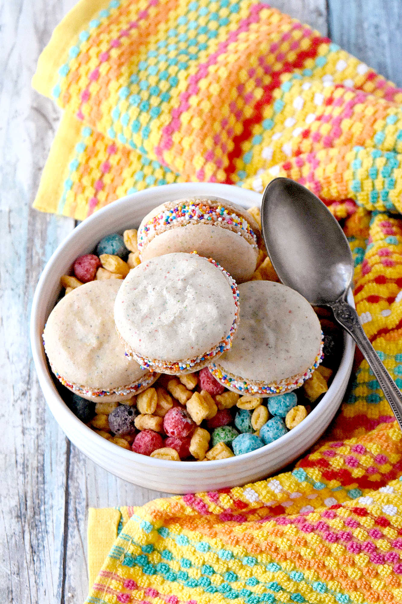 Cereal Milk Macaron taste like your favorite fruit cereal.  There's cereal in the shells and cereal milk in the buttercream.   #BacktoSchoolTreats