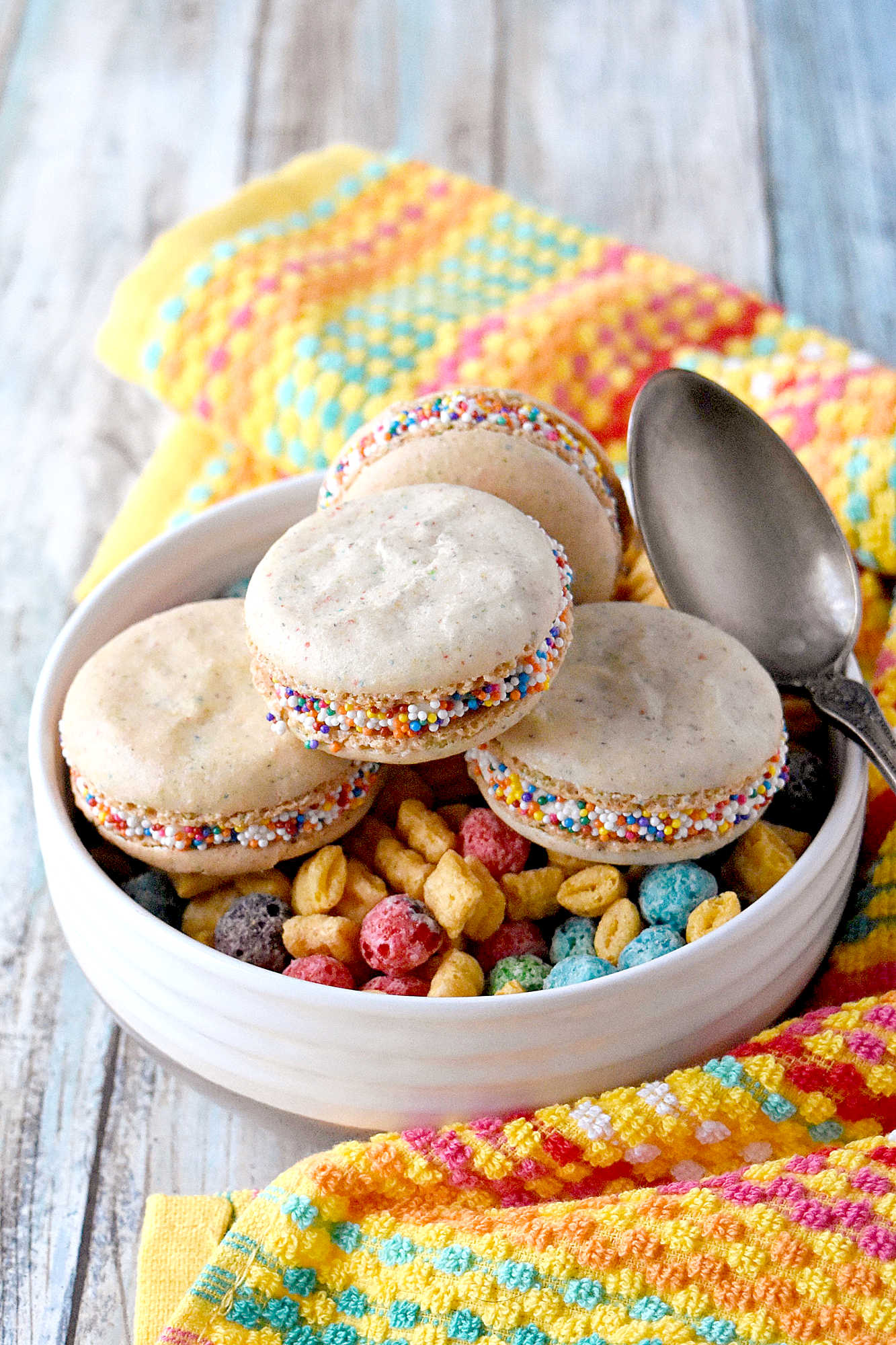 Cereal Milk Macaron taste like your favorite fruit cereal.  There's cereal in the shells and cereal milk in the buttercream.   #BacktoSchoolTreats