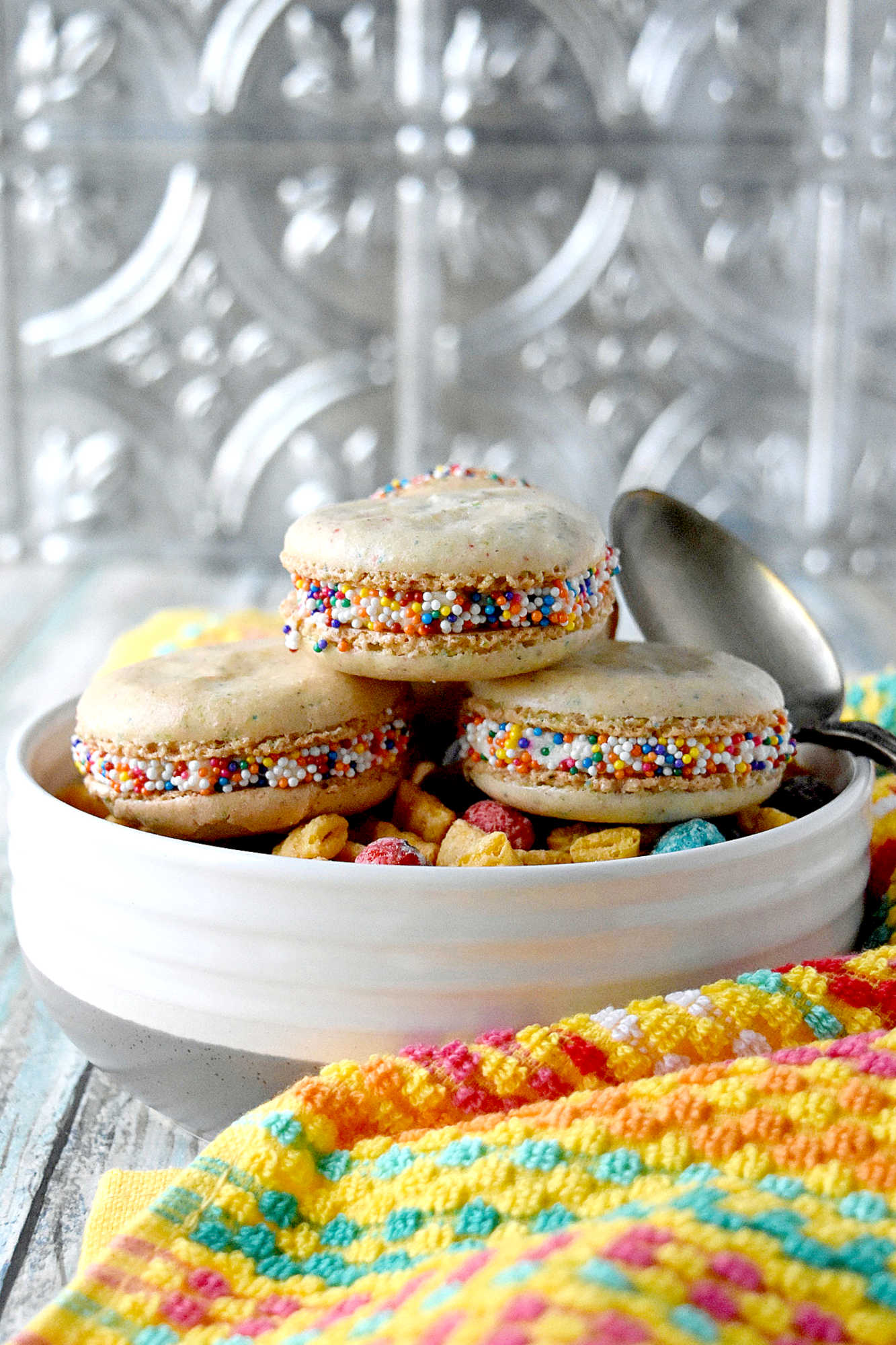 Cereal Milk Macaron taste like your favorite fruit cereal.  There's cereal in the shells and cereal milk in the buttercream.   #BacktoSchoolTreats