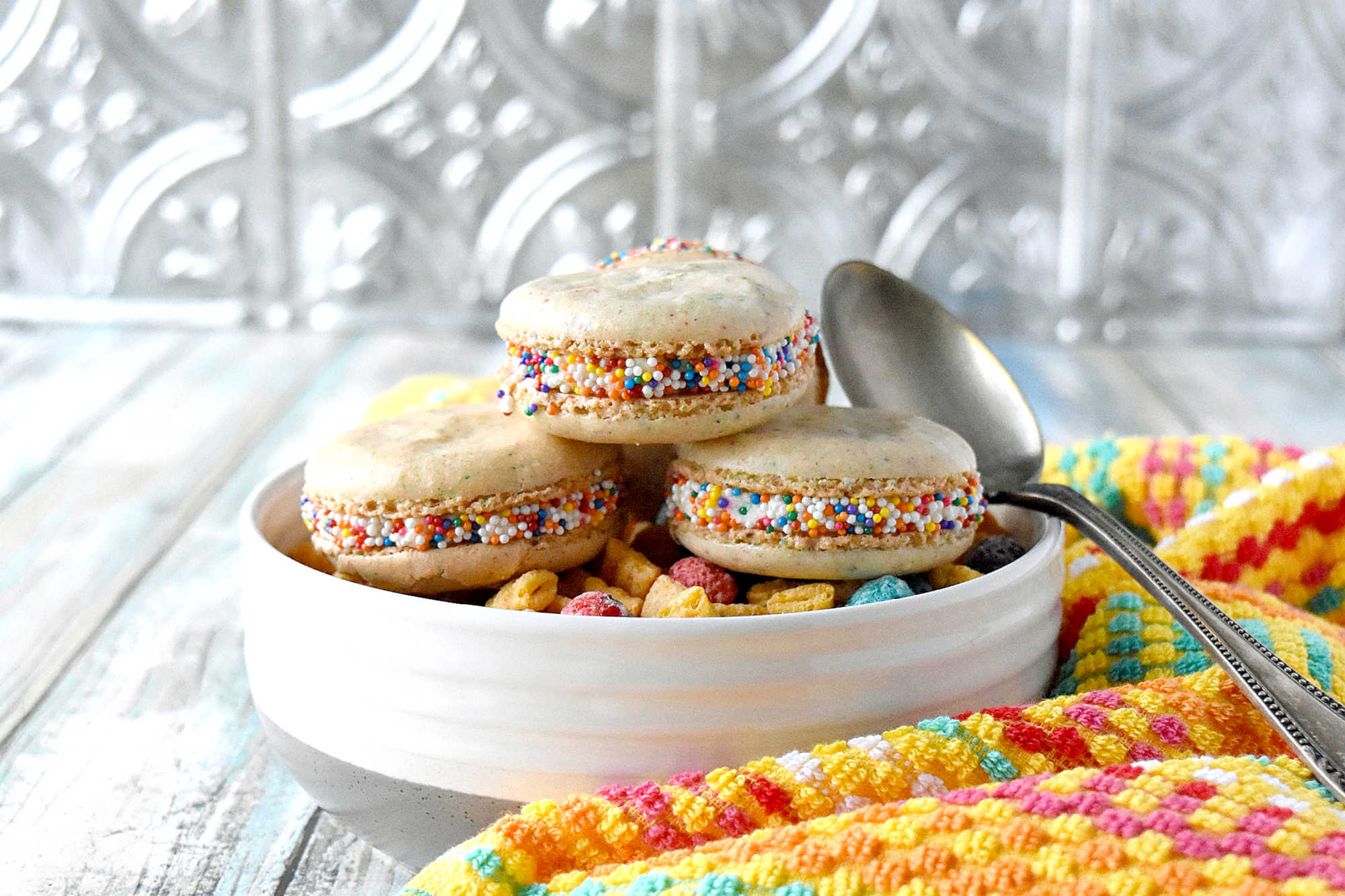 Cereal Milk Macaron taste like your favorite fruit cereal.  There's cereal in the shells and cereal milk in the buttercream.   #BacktoSchoolTreats