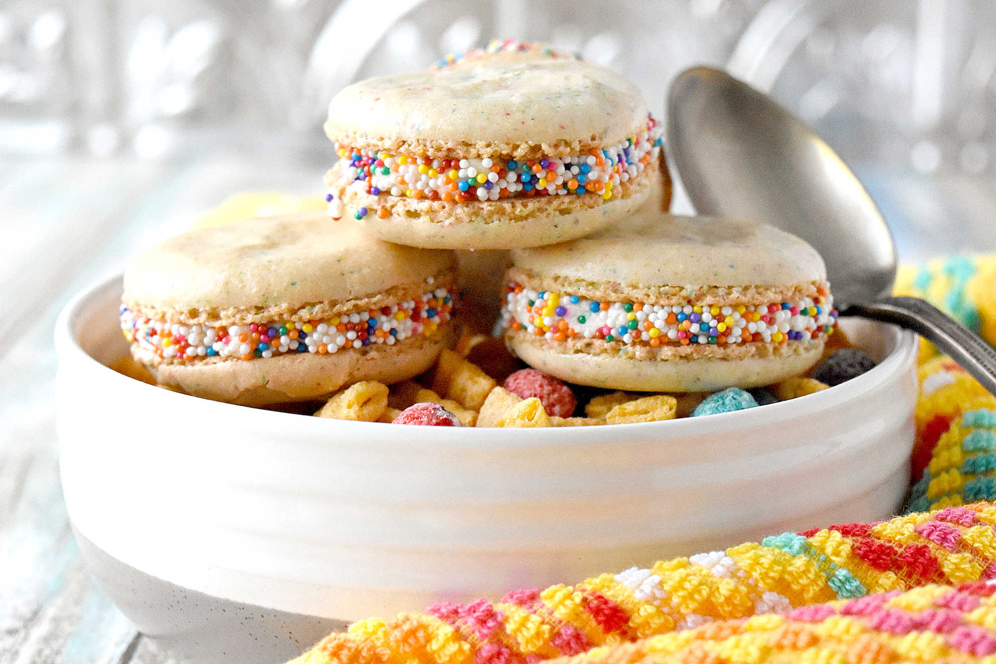 Cereal Milk Macaron taste like your favorite fruit cereal.  There's cereal in the shells and cereal milk in the buttercream.   #BacktoSchoolTreats