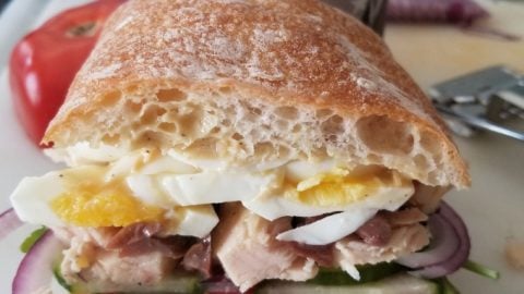 A delicious farmer’s market find tops this Dijon Pan Bangat sandwich. It’s rich, delicious, and packed with flavor. Perfect for picnics, pan bagnat need time to “marinate” before eating. #FarmersMarketWeek