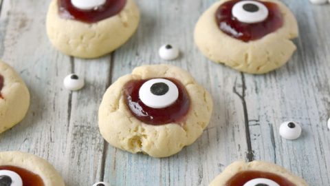 Turn a simple and easy thumprint cookie into Eyeball Thumbprint Cookies!  Filled with cherry jam and topped with large candy eyes for a fun Halloween treat. #HalloweenTreatsWeek