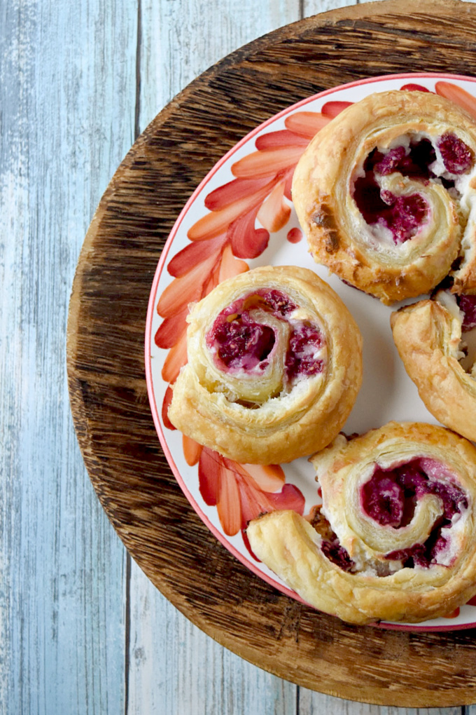 Raspberry Danish Pinwheels come together in minutes and taste simply delicious!  The delicious puff pastry, fresh raspberries, and cream cheese filling makes these irresistible.  #BerryWeek