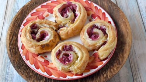 Raspberry Danish Pinwheels come together in minutes and taste simply delicious! The delicious puff pastry, fresh raspberries, and cream cheese filling makes these irresistible. #BerryWeek