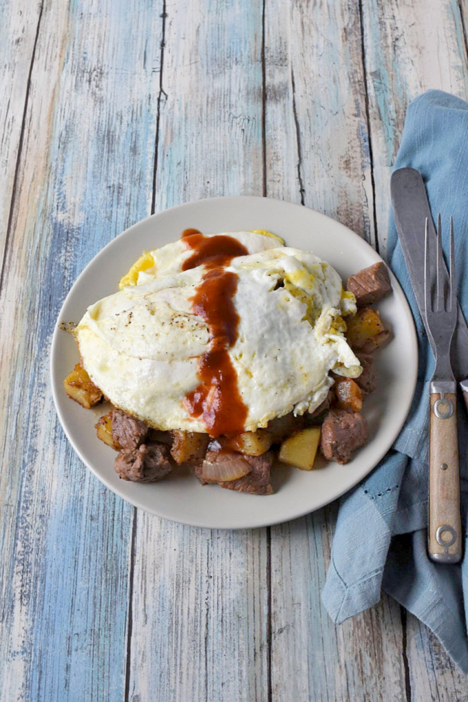 Steak and Potato Hash takes steak and eggs to a whole new level!  Kicked up with steak seasoning and a drizzle of steak sauce, it’s a hearty breakfast everyone will love. #BrunchWeek