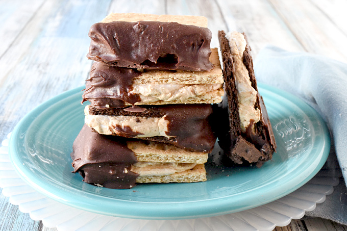 Fluffernutter Bites are a cross between a s'more and a fluffernutter sandwich.  Marshallow fluff and peanut butter are sandwiched between graham crackers and dipped in chocolate. #BacktoSchoolTreats